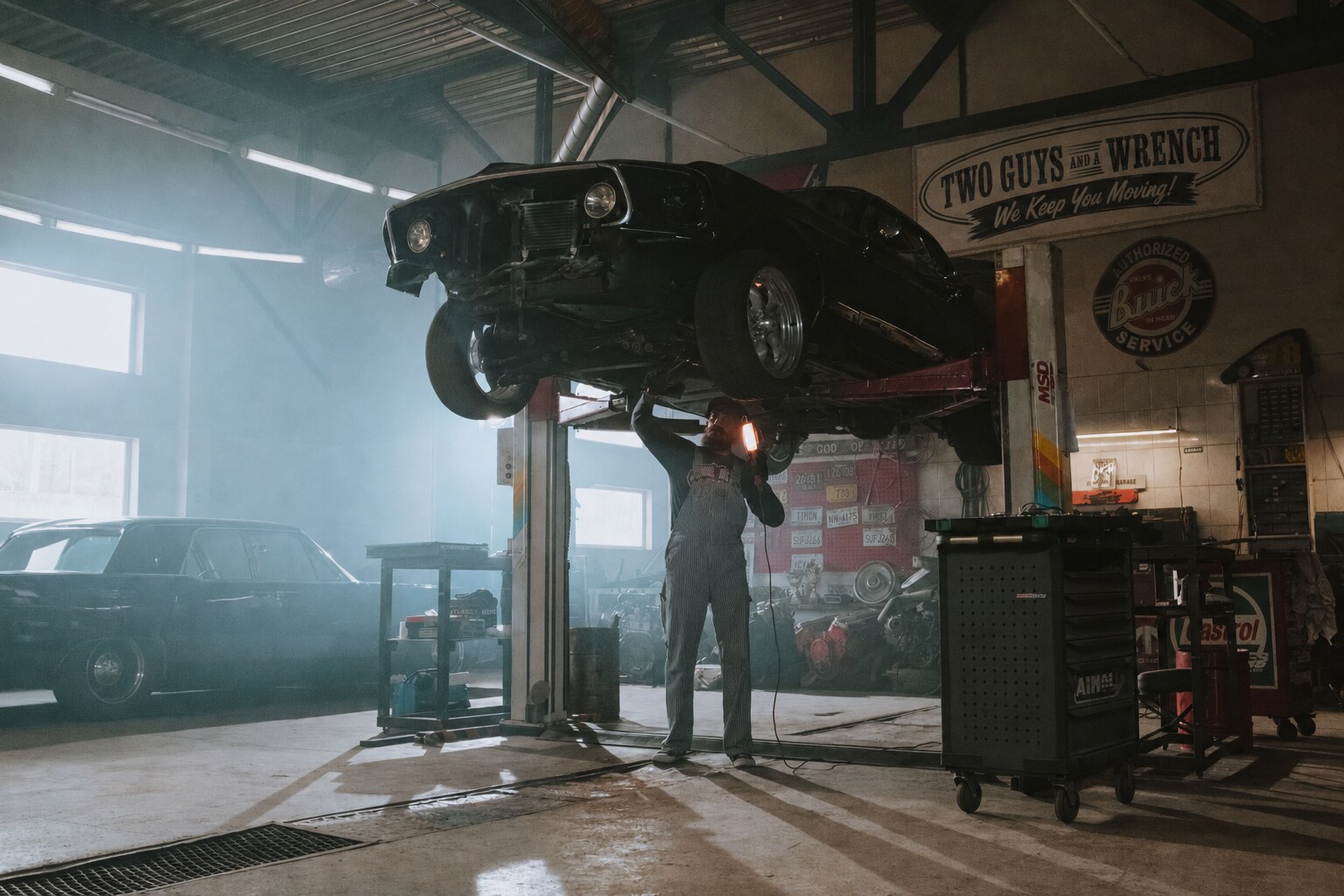 Mechanic servicing a classic car inside the Two Guys and a Wrench garage